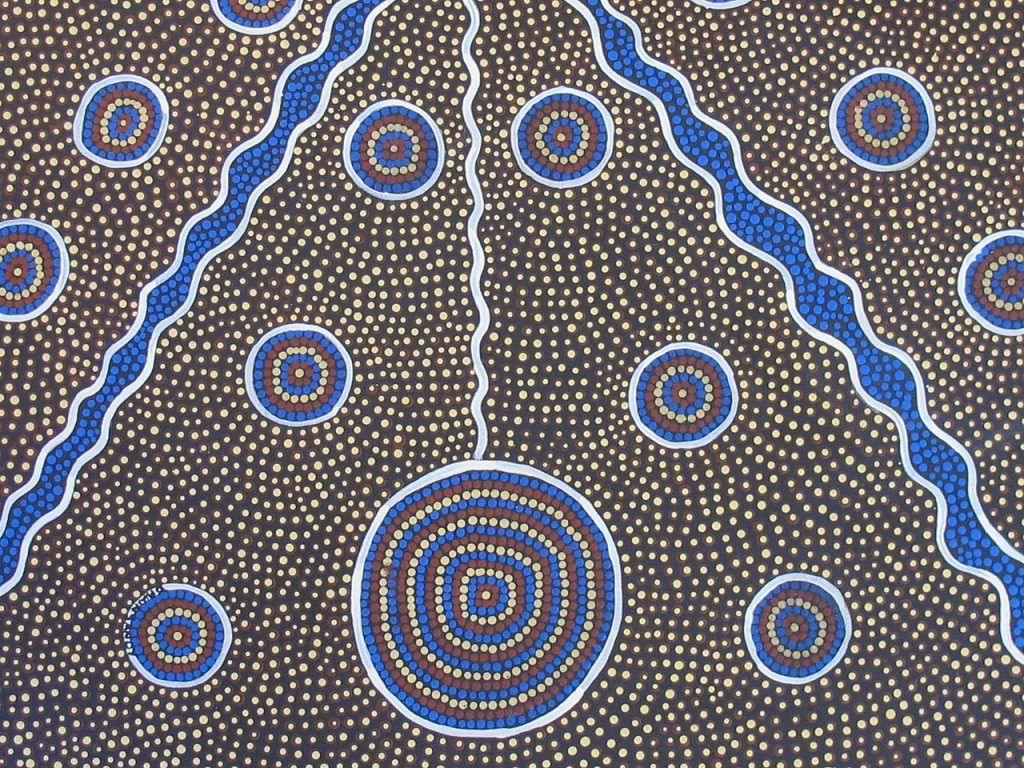 This artwork is an Australian Aboriginal dot painting in the style and tradition of the Central Desert people. It uses acrylic paint not traditional pigments