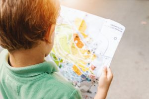 boy standing while reading map