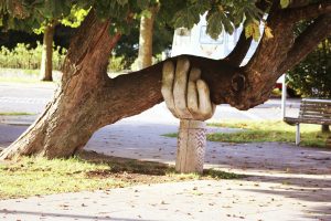 a timber hand holding up a heavy tree branch. 