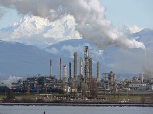 An industrial site with multiple tall towers set in front of mountains.