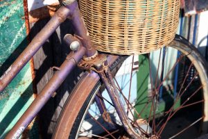 Image of a rusty bicycle with a cane basket.