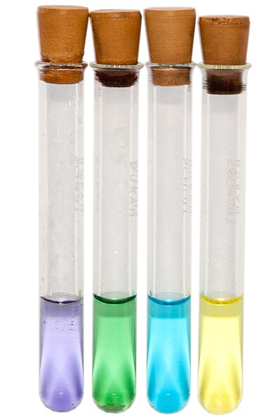 Four small test tubes, each containing purple, green, blue and yellow vanadium solutions.