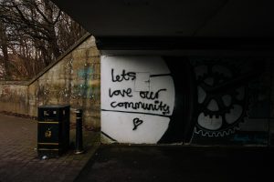 Graffiti saying 'lets love our community' with a love heart