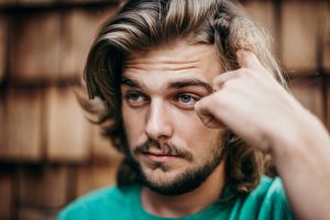 Man scratching head in front of files